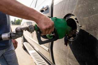 Person fills vehicle with fuel