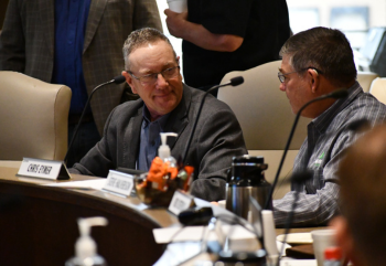Joel Erickson visits with fellow board member Chris Eymer at a board meeting