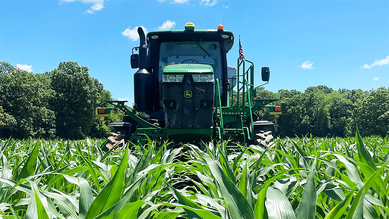 A John Deere tractor sitting in a field on a sunny day.