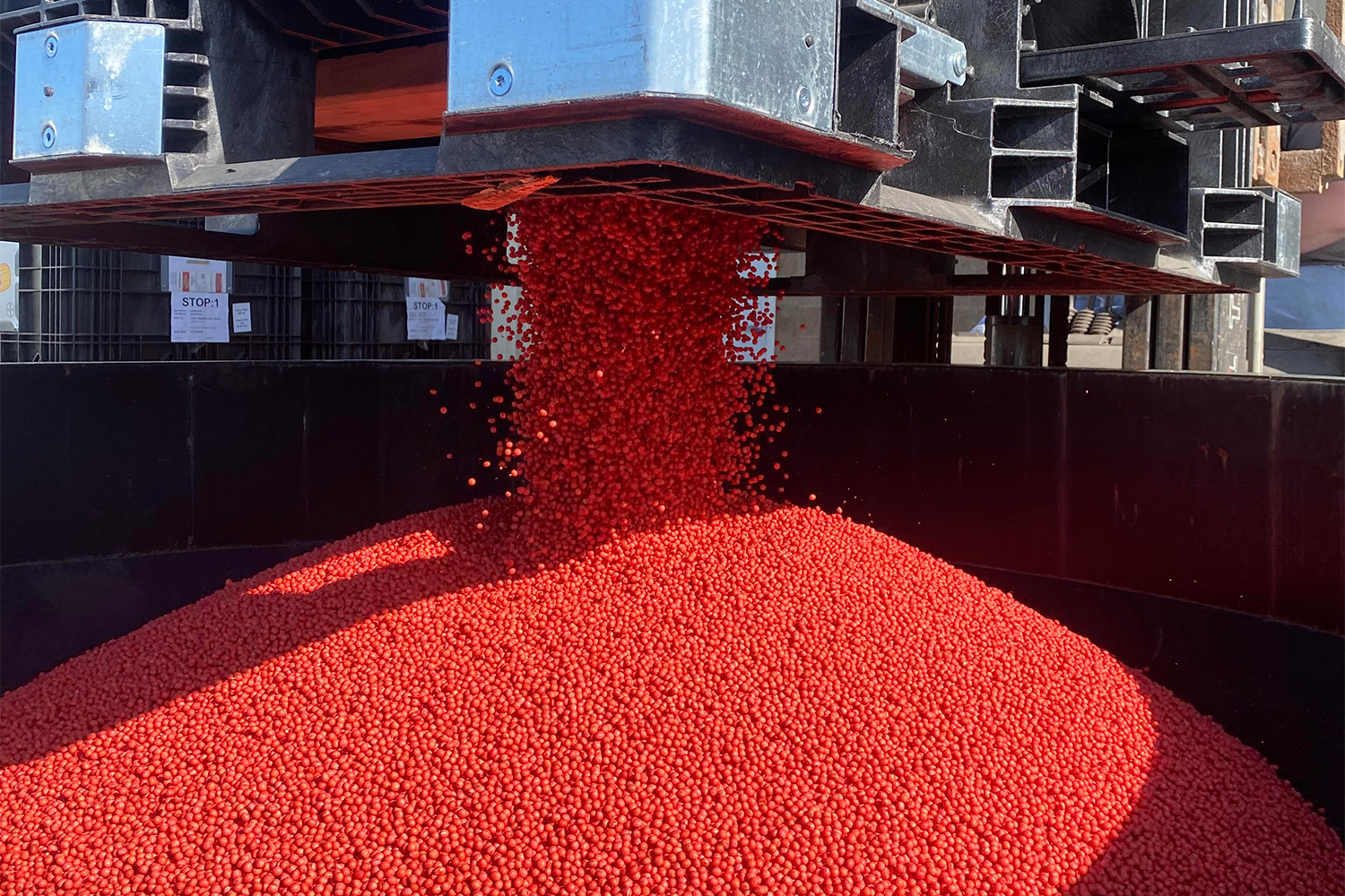 Crop nutrients being dumped into a tractor spreader.