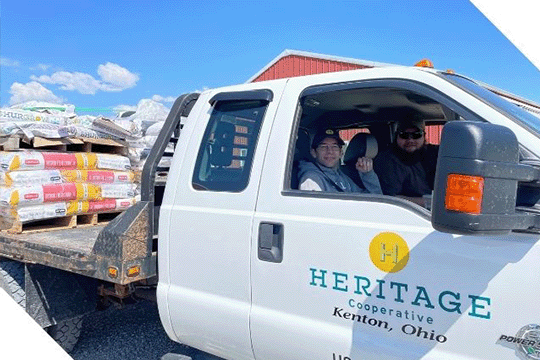 Heritage Associates Sitting in Flatbed Truck Hauling Fertalizer Bags