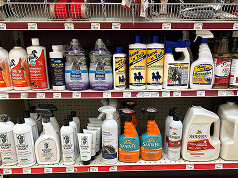 A shelf filled with various horse grooming products.