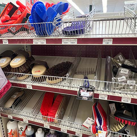 A shelf filled with various horse grooming products.