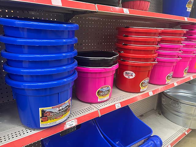 Shelves filled with various colored feed buckets.