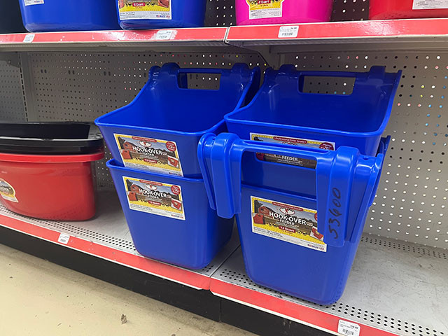 Shelves filled with various feed buckets.