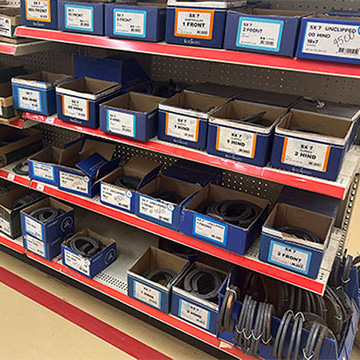 Shelves filled with boxes of variou sizes of horse shoes.