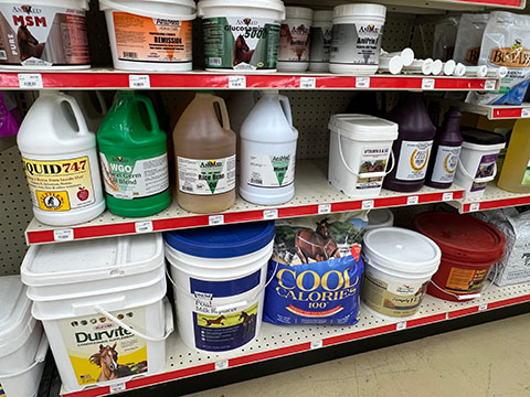 Supplements for horses on shelves.