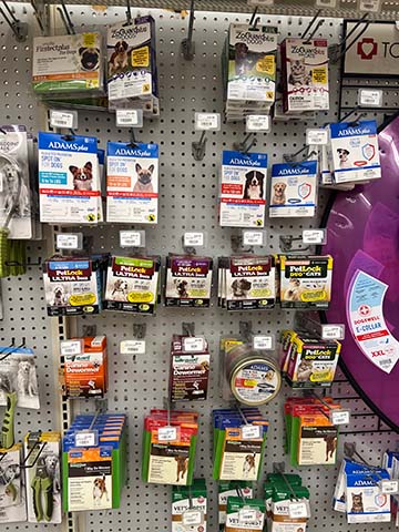 Flea and tick treatments on a wall display.