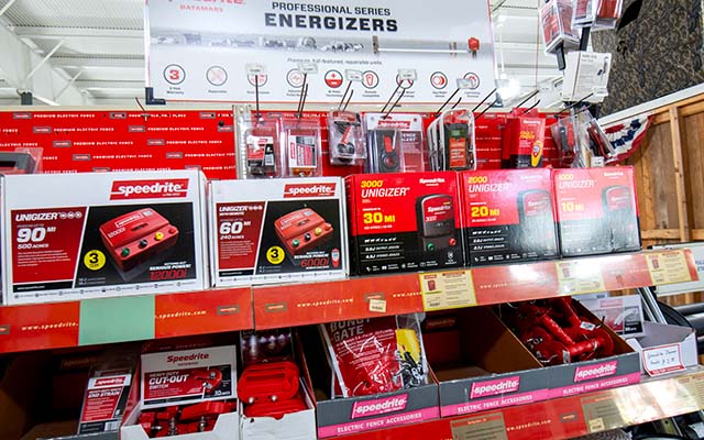 Shelves of energizers and other fencing supplies in the fencing section.