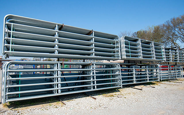 Several racks of fence gates outside.