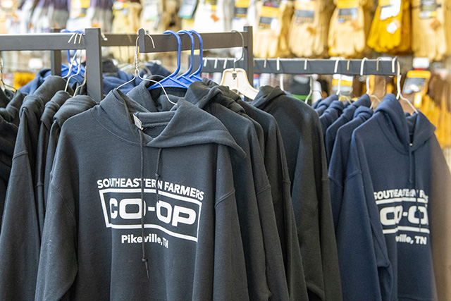 A clothing rack filled with Southeastern Farmers Co-op hoodies.