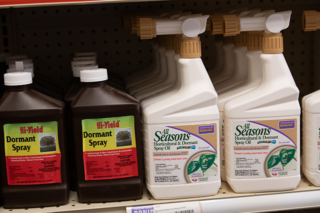 A shelf lined with bottles of dormant spray.