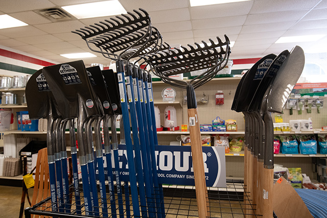 Shovels and rakes in a rack in the co-op.