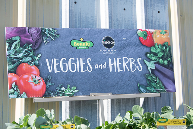 A close up of a Miracle Gro and Bonnie Plants veggies and herbs sign.