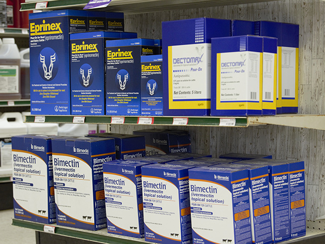 Shelves lined with pour on treatments for cattle including Eprinex, Dectomax, and Bimectin topical solutions