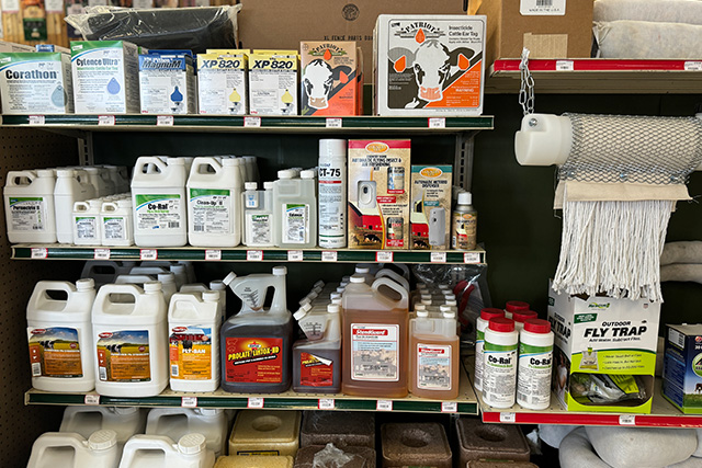 A shelf with cattle health products, ear tags, and supplements.