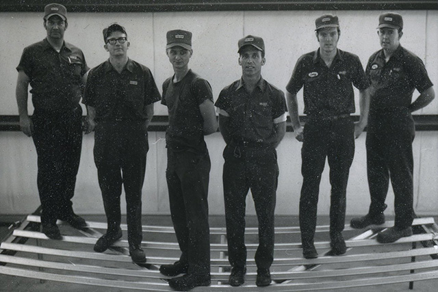 Workers from the metal fabrication warehouse standing on a gate to test its durability.