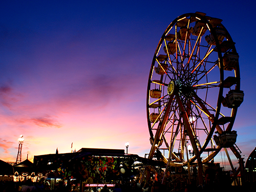 A sunset picture of a ferris wheel at the county fair