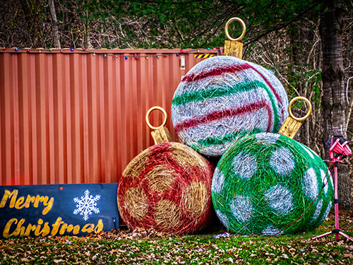 Hay bales painted and decorated to look like Christmas bulbs.