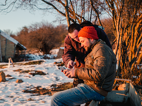 Two farmers looking at a phone