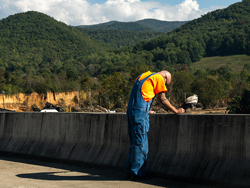 A farmer surveying his land after Hurricane Helene