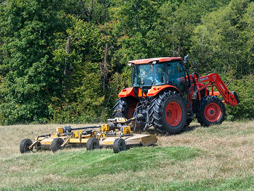 A tactor pulling a Bush Whacker rotary cutter.