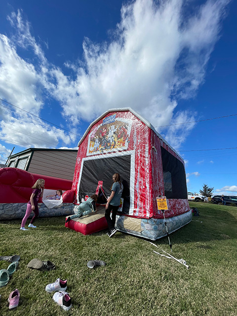 An inflatable bouncy house shaped like a big red barn.