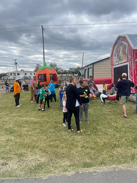 Crowds gather in front of the bouncy houses.