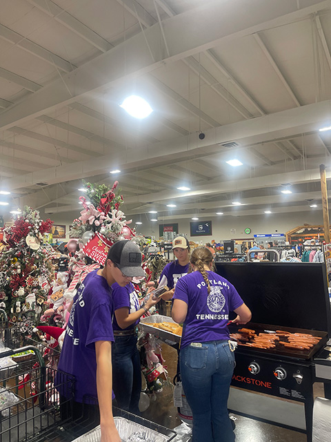 Workers grilling hotdogs and other foods at the Co-op.